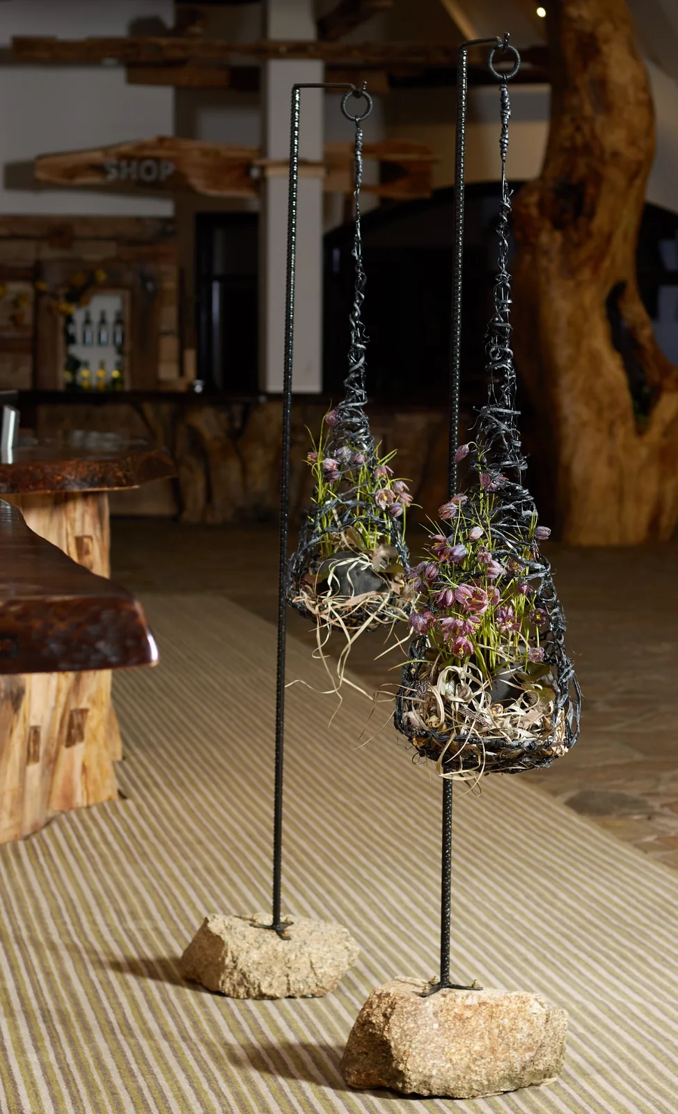 Skulpturale florale Objekte aus Metall mit zarten Blüten auf hohen Ständern