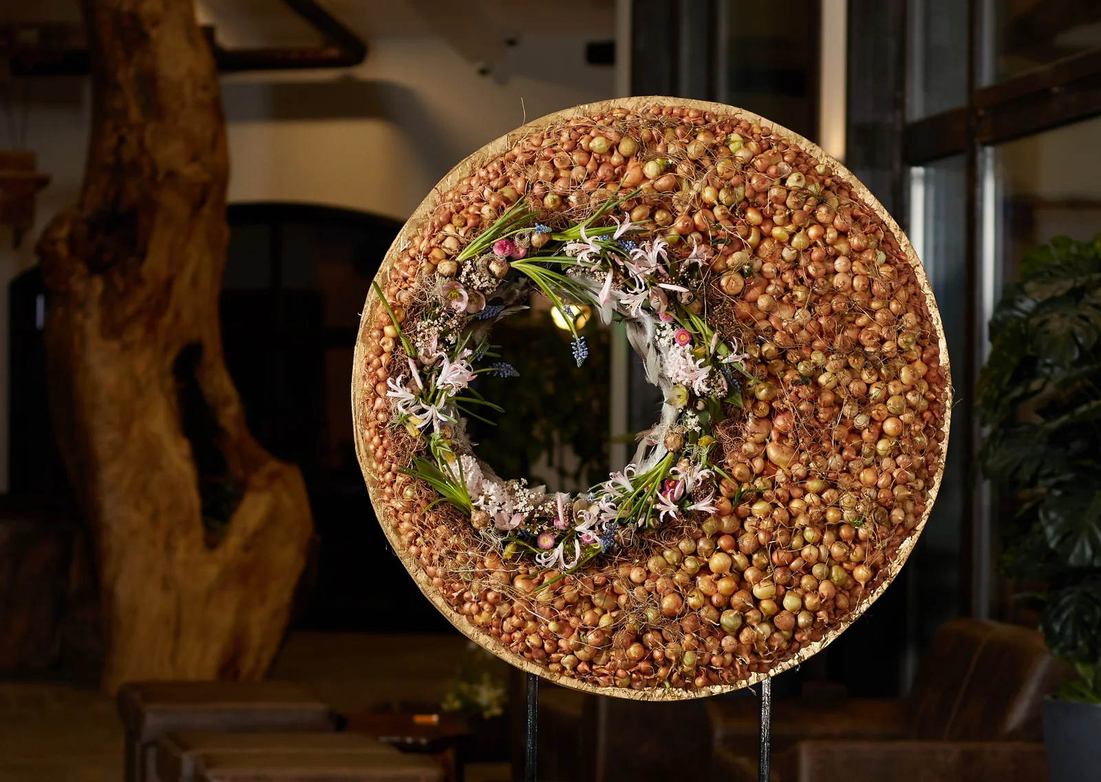 Detailansicht eines floralen Objekts aus Zwiebeln mit zarten Blüten und Gräsern