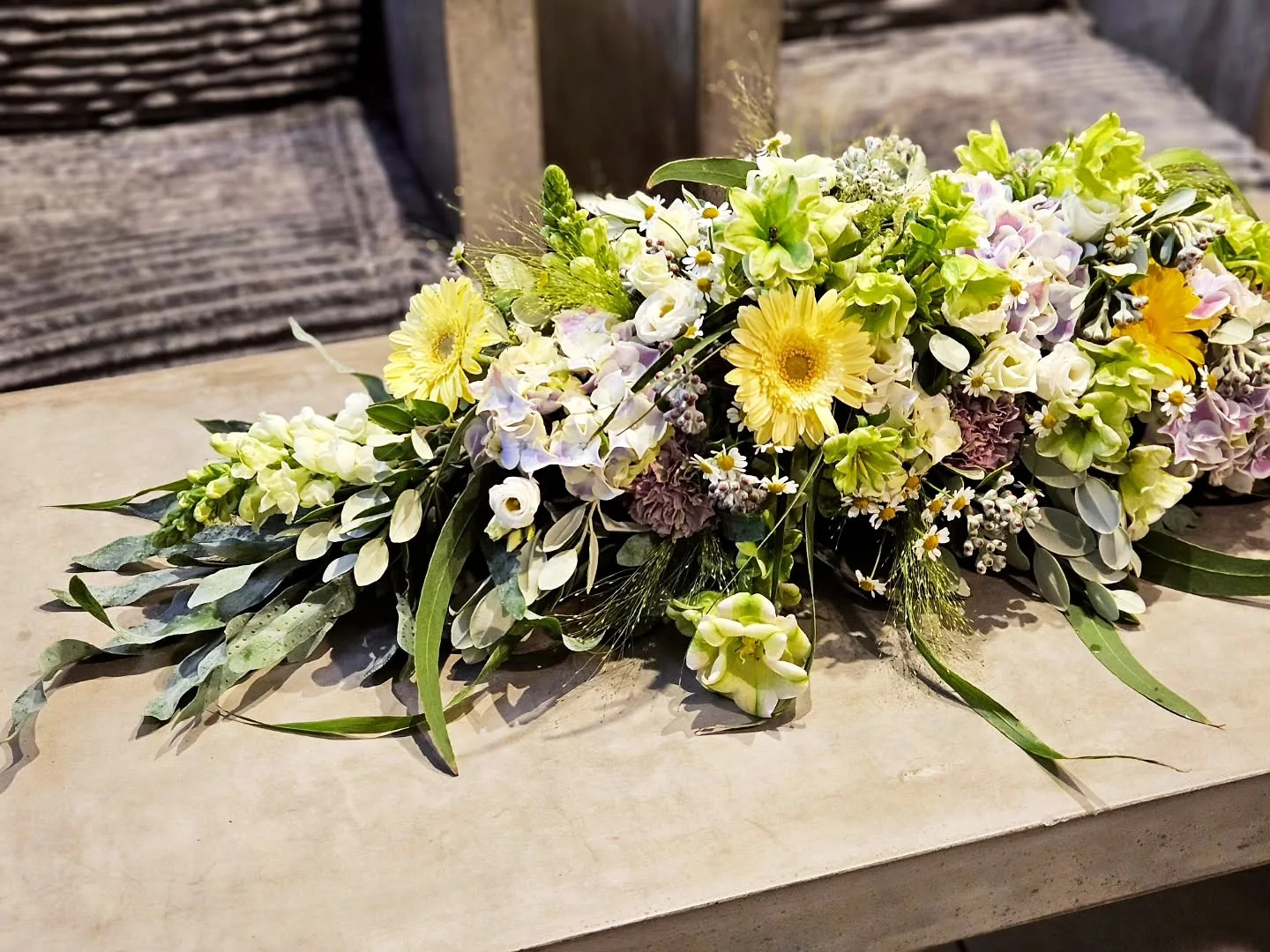 Üppige florale Tischdekoration in Grün, Gelb und Weiß mit Hortensien, Gerbera und feinen Blüten