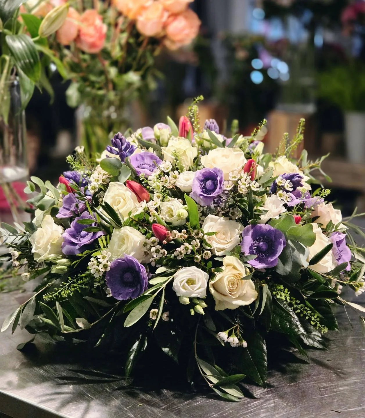 Trauergesteck in Weiß und Violett mit Rosen, Anemonen und feinem Grün