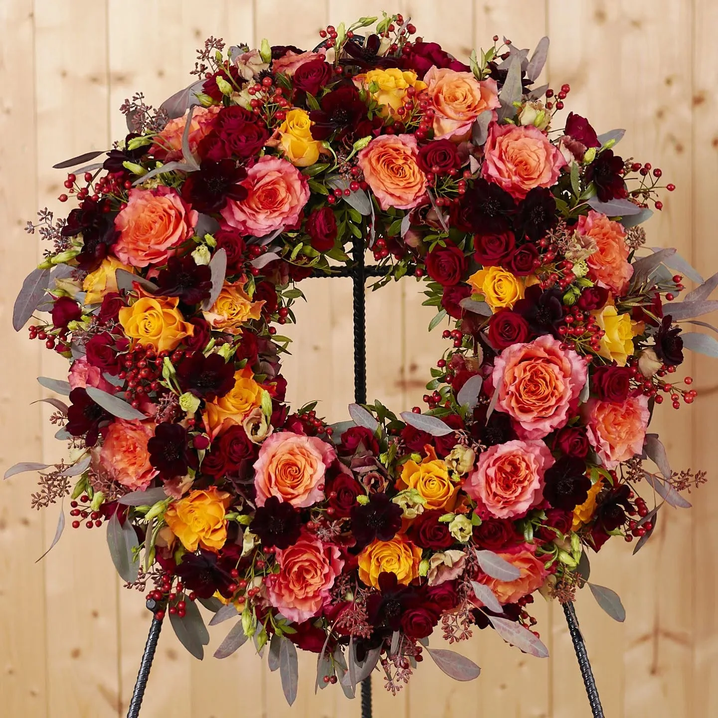 Farbenreicher Trauerkranz mit Rosen in Rot, Orange und Apricot