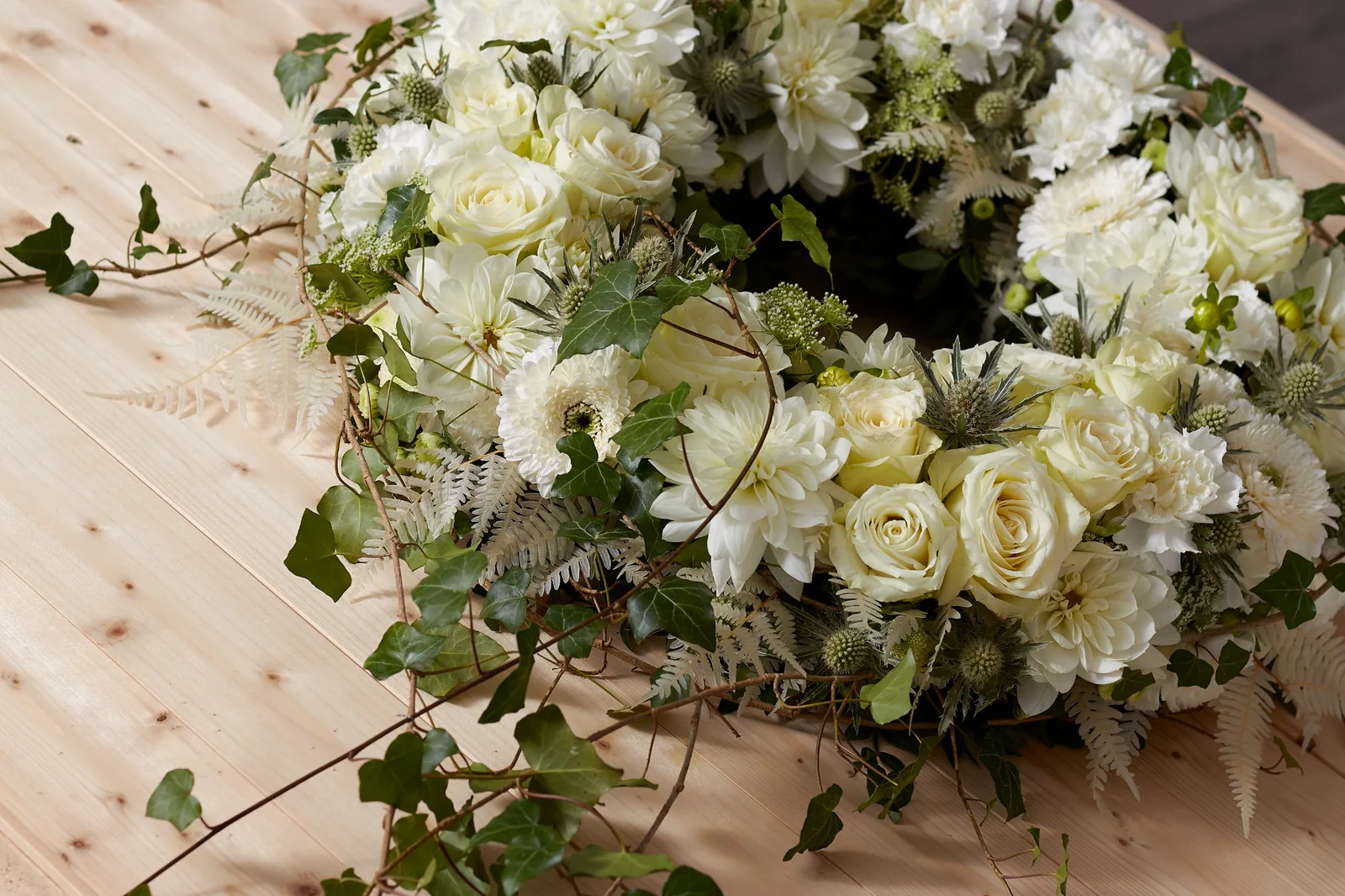 Weißer Trauerkranz mit Rosen, Dahlien, Nelken und Efeu